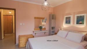 a bedroom with a white bed and a mirror at Medusa Beach Apartment, Asprovalta in Asprovalta