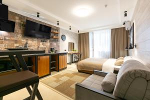 a hotel room with a bed and a flat screen tv at Giorgio-Haylaz-Home Апарт Отель in Krasnodar