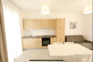 cocina y sala de estar con mesa blanca y sillas en Residence Valentina Int 5, en Santa Maria al Bagno
