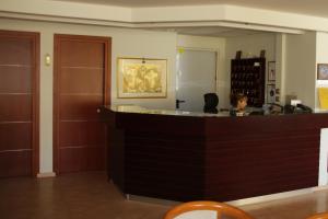 a woman sitting at a counter in a room at Saronis Hotel in Ancient Epidauros