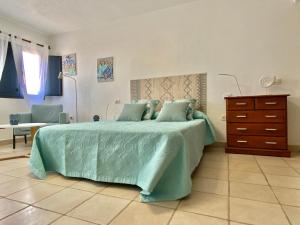 a bedroom with a large bed and a dresser at Maresia Holiday House in Caleta de Sebo