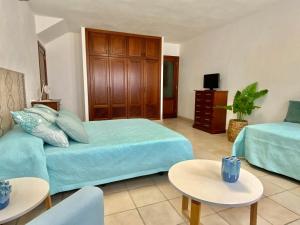 a bedroom with a bed and a couch and tables at Maresia Holiday House in Caleta de Sebo