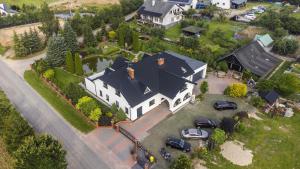 an overhead view of a large house with cars parked on the yard at Apartament Melania in Sarnowy