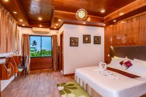 a room with two beds and a kitchen with a window at Summer Villa Guest House in Maafushi