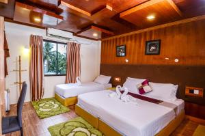 sypialnia z 2 łóżkami i oknem w obiekcie Summer Villa Guest House w mieście Maafushi
