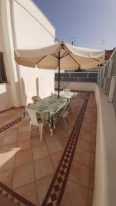 patio con tavolo e ombrellone sul tetto di CASA "JOLANDA" - SANNICOLA, A 5 KM DA GALLIPOLI a Sannicola