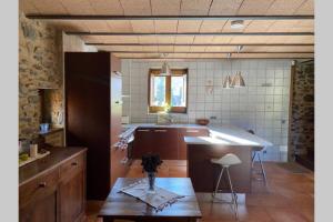 uma cozinha com um balcão e uma mesa em Cal Masover, casa de piedra rehabilitada em Planoles