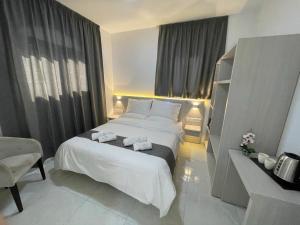 a bedroom with a large white bed with towels on it at La Veranda Hotel in Larnaca