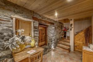 Habitación con mesa y pared de piedra. en Colettine, en Tignes