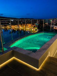 a swimming pool on the roof of a building at night at Hotel Atlas in Sete Lagoas