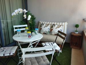 una mesa y sillas en una habitación con sofá en Junto Playa Levante con terraza Chill-Out-2 WCs-A ESTRENAR Gemelos 23, en Benidorm
