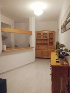 an empty room with a kitchen with wooden cabinets at TRIANA PUREZA 12-14 in Seville