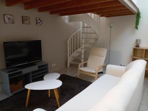 a living room with a white couch and a tv at STUDIO PROCHE PARIS ET DISNEYLAND PARIS in Champigny-sur-Marne