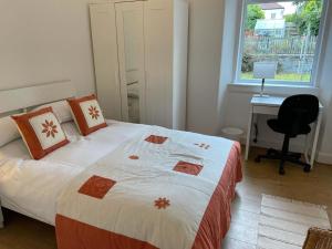 a bedroom with a bed with a desk and a window at Lade Braes 3 Bed Apartment Central St Andrews in St. Andrews