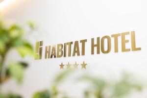 a sign that reads haciott hotel with four stars at Habitat Hotel Tirana in Tirana
