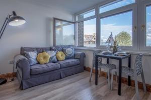 Ocean View - 1 Bedroom Apartment - Saundersfoot في ساندرزفوت: غرفة معيشة مع أريكة وطاولة
