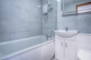 Ocean View - 1 Bedroom Apartment - Saundersfoot في ساندرزفوت: حمام أبيض مع حوض ودش