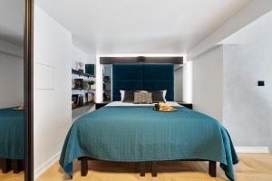 a bedroom with a blue bed and a mirror at Bob W Duo Lofts in Tartu