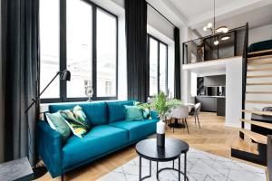 a living room with a blue couch and a table at Bob W Duo Lofts in Tartu