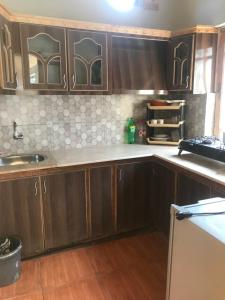 a kitchen with wooden cabinets and a counter top at ViveGee Cottage Khanipur Ayubia in Ayubia