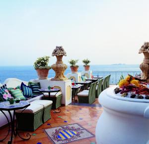 a restaurant with tables and chairs and a view of the ocean at Le Sirenuse in Positano