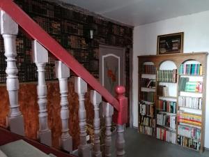a staircase with a book shelf with books at Hôtellerie Jardiniers Gourmands in Morsains