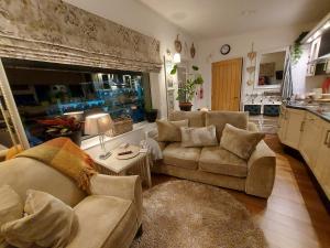a living room with two couches and a kitchen at Hillside Cottage in Letterkenny