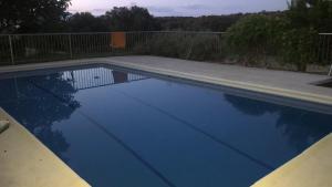 une piscine avec de l'eau bleue dans une cour dans l'établissement La Cerca Del Alcornoque, à Casas de Belvis