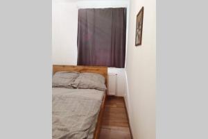 een kleine slaapkamer met een bed en een raam bij Apartament Źródełko in Bochnia