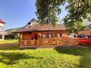 ein Holzhaus mit einem Zaun im Hof in der Unterkunft Casa Luca in Vişeu de Jos