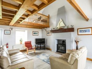 a living room with a couch and a fireplace at Bodlasan Groes House in Holyhead
