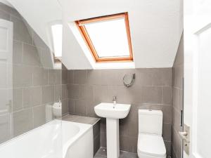 a bathroom with a sink toilet and a window at Bodlasan Groes Cottage in Holyhead +21 photos