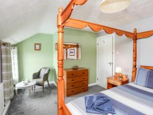 a bedroom with a bed and a desk and a chair at Bodlasan Groes Cottage in Holyhead