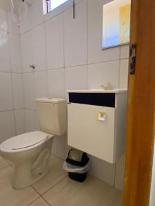 a white bathroom with a toilet and a sink at Hotel Pousada Aeroporto in Ponta Porã