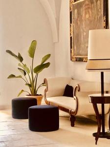 a living room with a couch and a plant at Casa d'Autore in Ostuni +26 photos