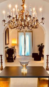 a chandelier in a living room with a table at Casa d'Autore in Ostuni