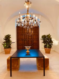 a dining room with a table and a chandelier at Casa d'Autore in Ostuni