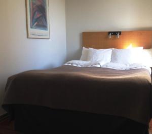 Rúm í herbergi á Grand Hotel Falkenberg