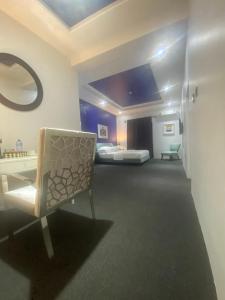 a room with two beds and a chair in it at MUSE Boutique Hotel in Enugu