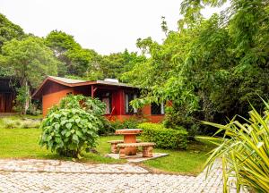 una mesa de picnic en un jardín frente a una casa en Cabañas La Pradera, en Monteverde
