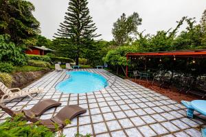 a patio with chairs and a swimming pool at Cabañas La Pradera in Monteverde Costa Rica