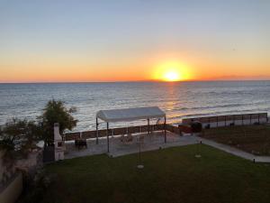 un coucher de soleil sur l'océan avec un belvédère dans l'établissement Venetico Beachfront Apartments & Suites - Sea View Studio, à Argassi 17 autres photos