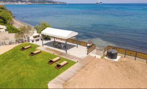 une vue aérienne d'un pavillon avec des chaises et de l'eau dans l'établissement Venetico Beachfront Apartments & Suites - Sea View Studio, à Argassi