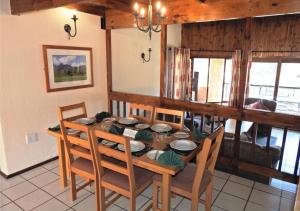 a dining room with a wooden table and chairs at Fairways Holiday Accommodation in Drakensberg Garden