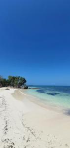 una playa de arena con el océano en el fondo en El Embrujo Tintipan en Tintipan Island