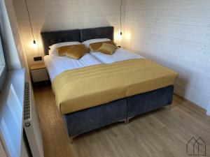 Un dormitorio con una cama grande con almohadas amarillas. en Nowa Stodoła, en Władysławowo