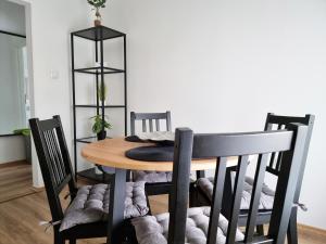 uma mesa de jantar com cadeiras pretas, uma mesa e uma espreguiçadeira em Apartment Julija em Opatija