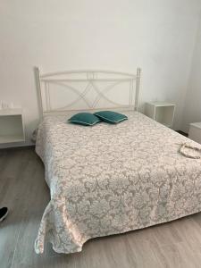 a white bed with two green pillows on it at VILLA IRMA in Varigotti
