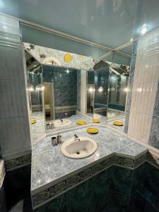 uma casa de banho com um lavatório e um espelho grande em Great one Bed right near Opera House em Kiev