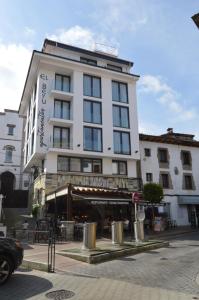 a tall white building on a city street at Apartamentos el Beyu in Cangas de Onís